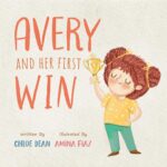 Children's book cover titled "Avery and Her First Win" by Chloe Dean, illustrated by Amina Fiaz. Features a smiling young girl with curly brown hair in pigtails proudly holding up a gold star trophy.